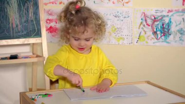 Evde resim çizen küçük tatlı bir anaokulu çocuğu.