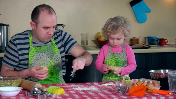 Padre caucásico y su hija se divierten desplegando masa de galletas en la cocina — Vídeos de Stock