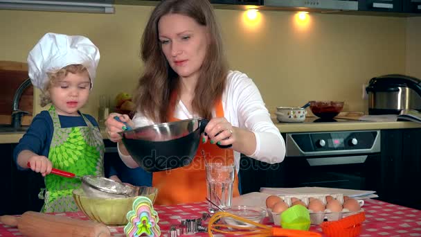 Donna felice con la sua adorabile figlia ragazza setacciando farina per la cottura della torta — Video Stock