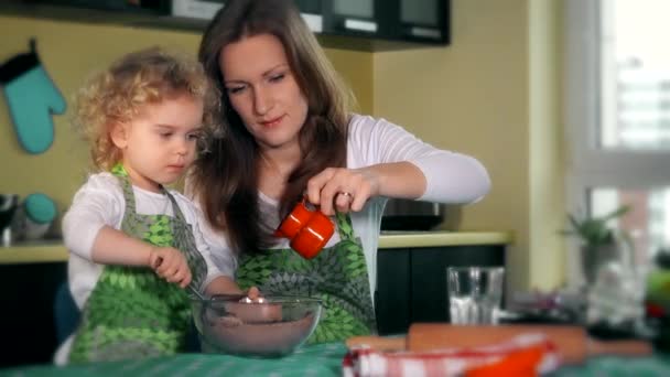 Vackra mamma lär dotter förbereda degen i köket. familjen glad — Stockvideo