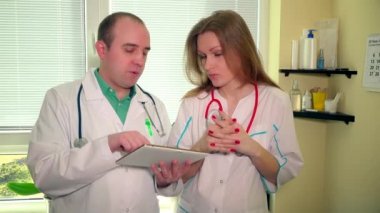 Tablet bilgisayar ekranına bakarak iki doktor arkadaşları erkek ve kadın iddia