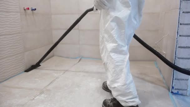 Travailleur homme en blanc construction globalement propre reste et aspirateur de poussière — Video