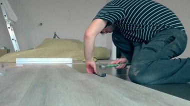 Basit adam döşeme Laminant zemin kurullarında çekiç ile.