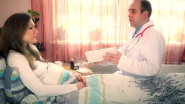 Doktor adam gösteren dijital tablet bilgisayar olan hasta kadın konuşuyor