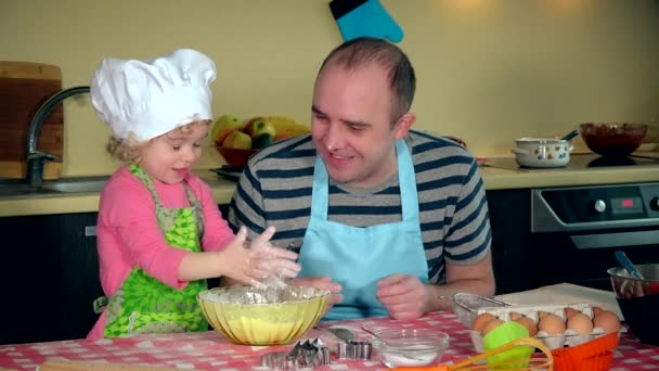 Lustiges Porträt der süßen kleinen Tochter mit dem hübschen Vater, der mit Mehl spielt — Stockvideo