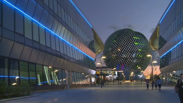 Costruzione di sfera moderna di EXPO e la gente di visitatori che cammina in sera — Video Stock