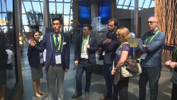 Male guide showing modern exposition stand in Expo 2017 exhibition — Stock Video