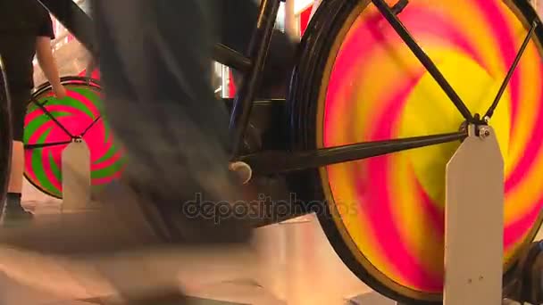 Benen op kleurrijke statische pedaal van een fiets het genereren van elektriciteit — Stockvideo