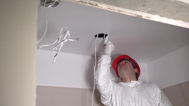 Progettista uomo che fa foro in cartongesso soffitto per l'installazione elettrica — Video Stock