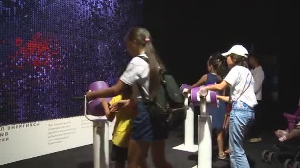 Gruppe von Kindern spielt mit Kanonen auf bunte Leinwand in der Ausstellung — Stockvideo