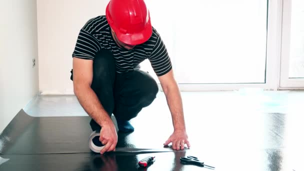 Travailleur professionnel homme taping sol sous-couche avec ruban adhésif . — Video