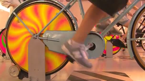 Atractiva mujer sonriente en pantalones cortos en bicicleta de pedal eléctrico en exposición — Vídeo de stock