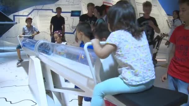 Enfants se balançant sur tuyau hydrotube avec de l'eau bleue en Allemagne exposition — Video