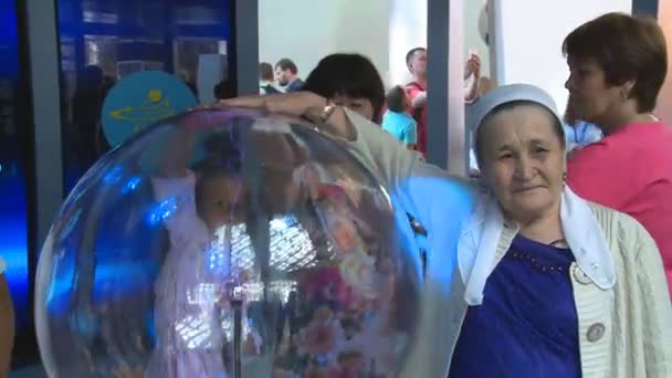 Senior Kazakiska kvinna touch glaskula plasma boll med El makt strålar — Stockvideo