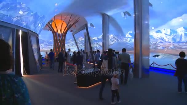 Pessoas que visitam pavilhão com árvore moderna e ovo e projeções de montanha — Vídeo de Stock