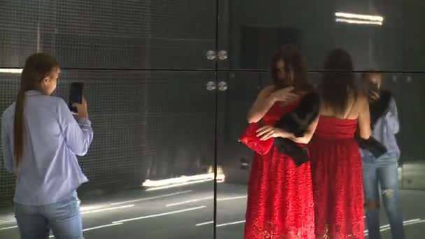 Mädchen fotografiert ihre kasachische Mutter in Rot auf Laserinstallationswand — Stockvideo