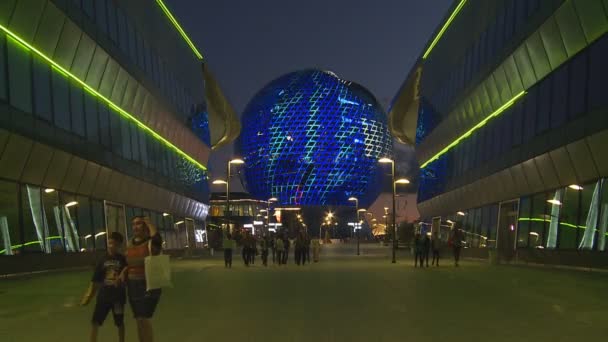 Turistické lidí navštěvující moderní koule architektura budovy s barevnými světly — Stock video