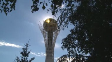 Bayterek kule mavi gökyüzü arka plan ağaç dal ve güneş ışınları yoluyla görünür