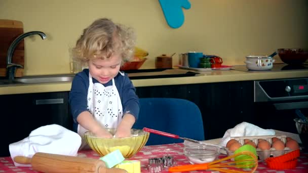 Непослушная маленькая девочка хлопает в ладоши мукой с закрытыми руками. мини шеф-повар на кухне — стоковое видео