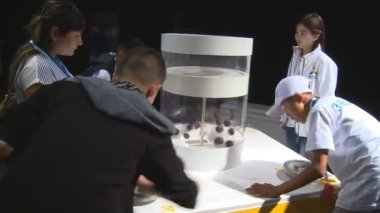 İnsanlar kolu moleküllerin hareketi gösterilen etkileşimli Fuar stand içinde açın.