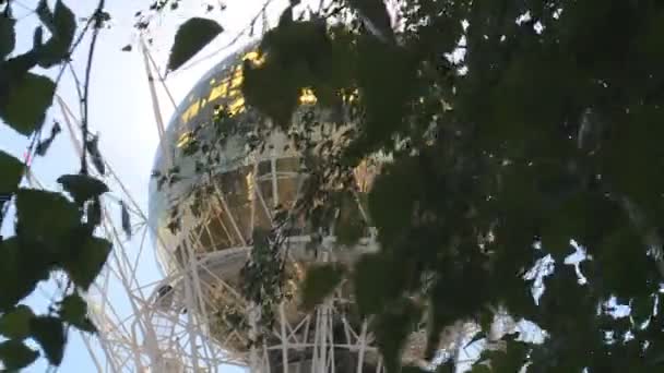 Boule de Bayterek Tour visible à travers les branches d'arbres et les rayons du soleil . — Video