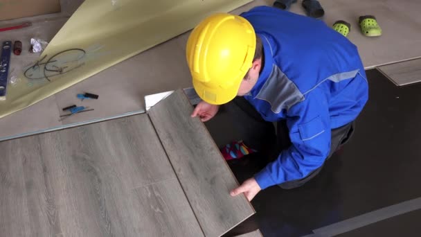 Hombre manitas poner tableros laminados de madera en el suelo en la nueva habitación de la casa — Vídeo de stock