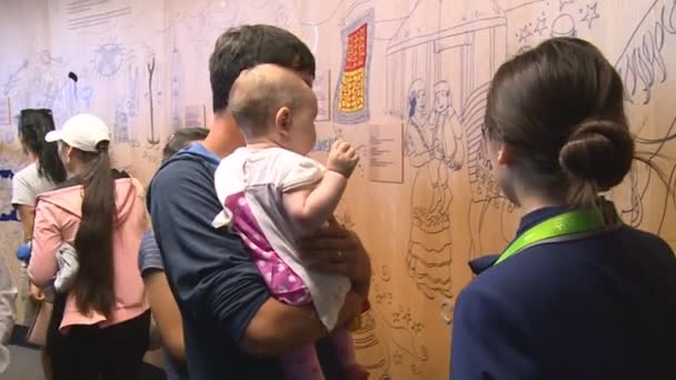 Kazakh mensen met kinderen genieten van interactieve kleurrijke muur in expositie — Stockvideo