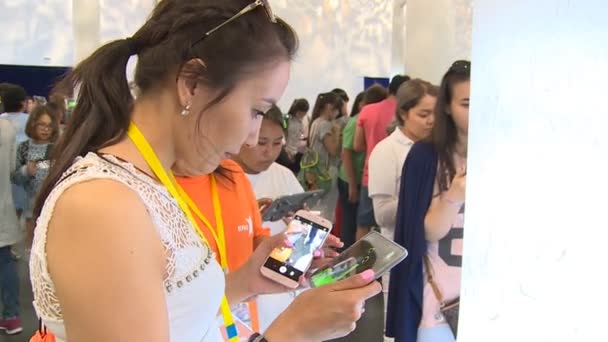 Jovem usando tablet interativo e smartphone no pavilhão coreano — Vídeo de Stock