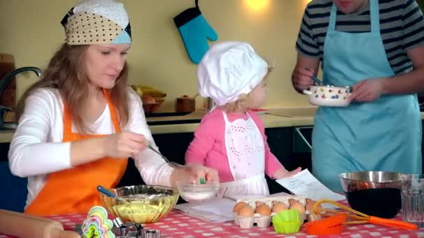 Familia feliz en la fabricación de galletas en casa. Padre madre e hija juntas — Vídeos de Stock