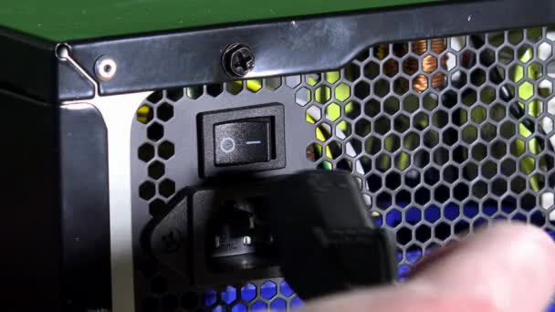 Hand in Schutzhandschuhen Kabel an Computernetzteil anschließen, Knopf drücken — Stockvideo