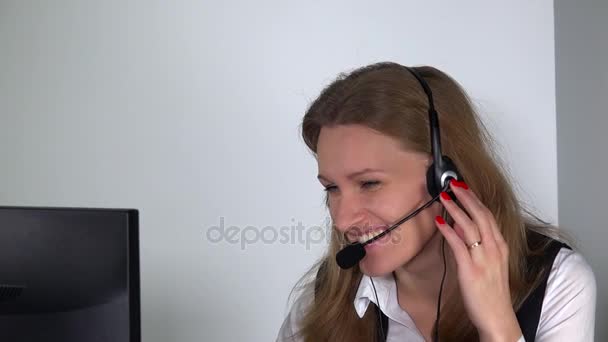 Asistente consultora sonriente con auriculares mirando la cámara y el ordenador — Vídeos de Stock