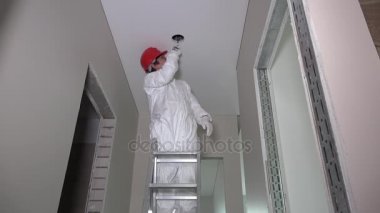 Merdiven ve koridor tavan delik kesme duran erkek işçi