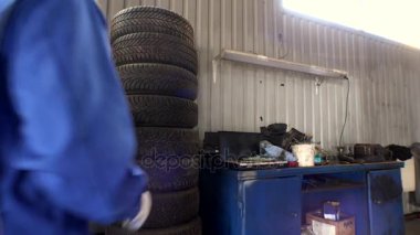 Lastikler ve mekanik yığını bir tane al. Mevsimlik otomobil lastiği değiştirmek garajda.