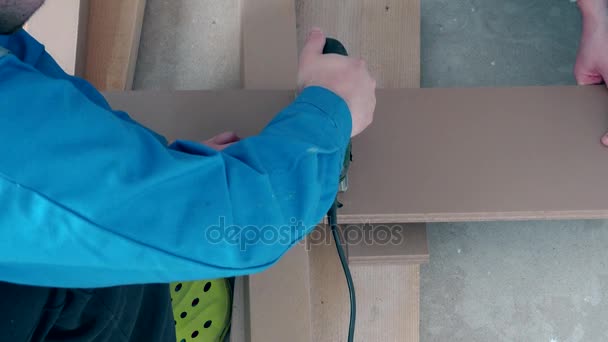 Handyman che adatta il bordo di legno laminato del pavimento per adattarsi alla pavimentazione — Video Stock