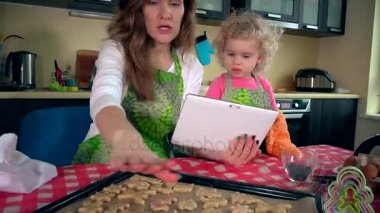 Mutlu aile kızlar Kurabiye Pişirme ve tablo bilgisayarda arıyorum