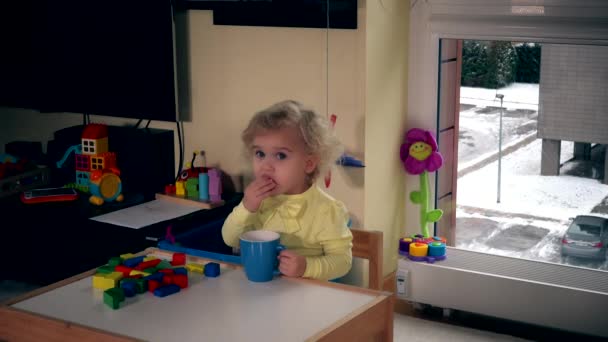 Тоддлер девочка ребенок пить чай с бубликами дома — стоковое видео