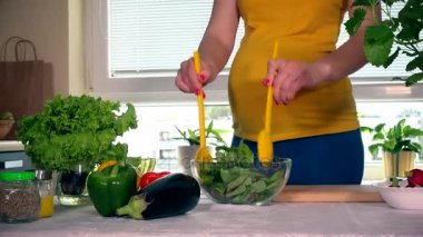 Hamile kadın cam tabak salata karıştırma