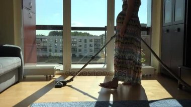 Büyük göbek ile elektrik süpürgesi hoover Oda elbiseli olan hamile kadın