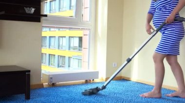 Hamile kadın eşi elektrikli süpürge odası ve oturup dinlenmek için Radyatör