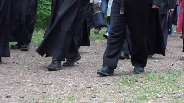 Sacerdotes y monjes en piernas soutane caminando por camino de grava camino forestal — Vídeo de stock