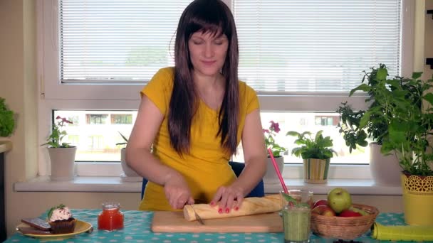 Zwangere vrouw stokbrood brood snijden met een mes op de snijplank — Stockvideo