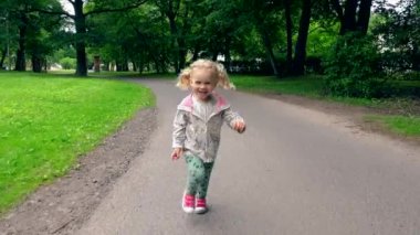 Kamera önünde park yol aracılığıyla çalışan pigtails ile sarışın kız