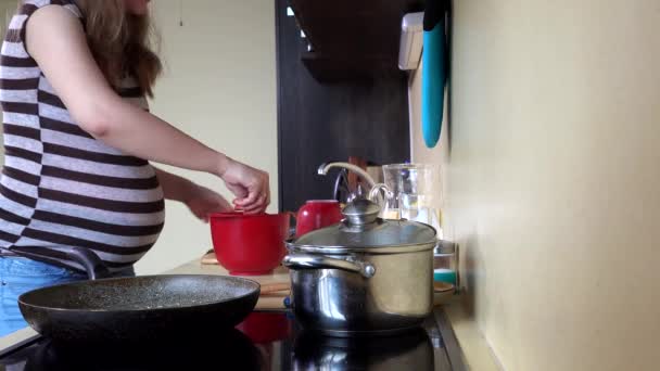 Pregnant house wife woman spice meat and put into cooking pan on hob — Stock Video