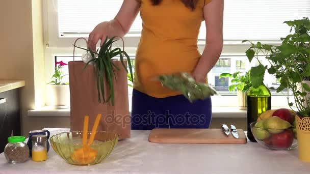 Hamile kadın taşıma çantaları ile organik sebze ve mutfak masasının üstünde kaldırma — Stok video