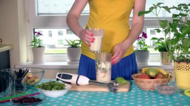 hamile Olgun kadın karıştırma süt mutfakta meyve kokteyli