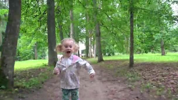 Freches kleines Mädchen läuft vor laufender Kamera durch Park-Baumallee — Stockvideo