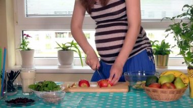 Hamile kadın mide ve eller elma meyve kesme tahtası üzerinde Dilimleme