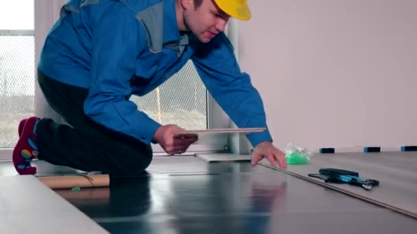Pracovník položit laminátovou podlahu. — Stock video