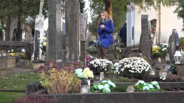 Mujer de luto cerca de lápida de mármol en el cementerio en otoño. 4K — Vídeo de stock