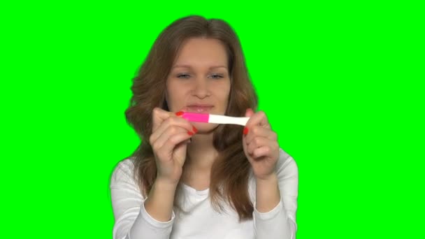 Joyeux jolie femme tenant test de grossesse positif en regardant la caméra avec joie — Video